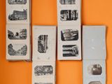 many books on the wall with pictures of buildings on them