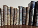 plusieurs vieux livres sont alignés sur une table en bois