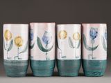 four vases with flowers painted on them on a table