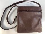 brown leather cross body bag with shoulder strap on white background
