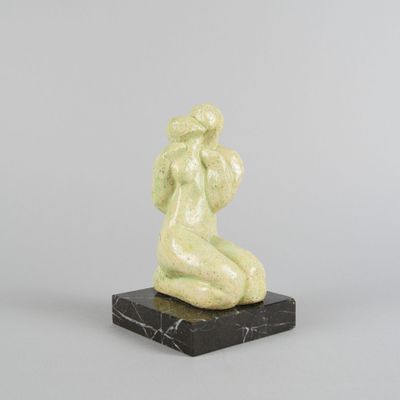 une photo d'une sculpture représentant une femme assise sur un socle en marbre