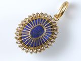 a close up of a gold and lapis stone pendant on a white background