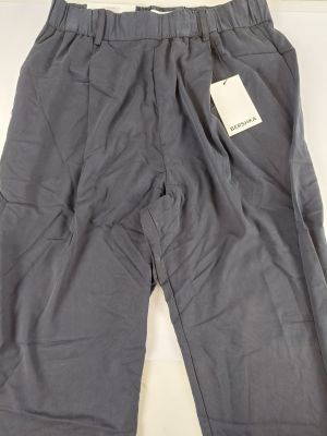 un pantalon gris posé sur une table blanche