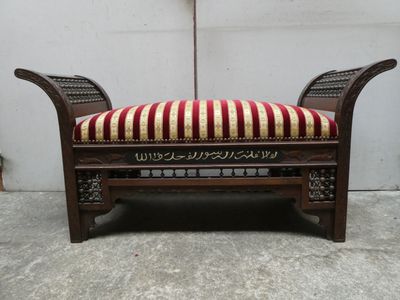 un banc en bois sur lequel est posé un coussin rayé