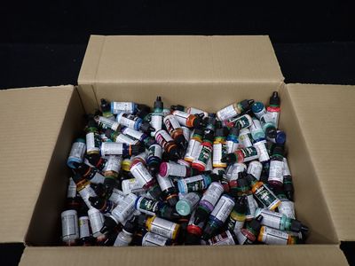 une boîte en carton remplie de bouteilles d'alcool posée sur une surface noire