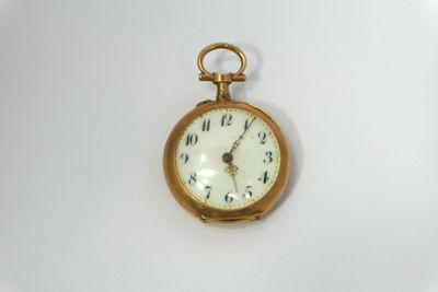 a small gold pocket watch on a white surface
