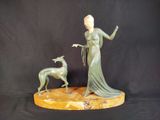 statue en bronze représentant une femme et un chien, posée sur un socle en marbre