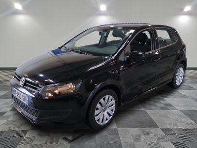 the black volkswagen polo is parked on a checkered tile floor