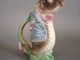 une figurine représentant un poisson portant un pull et un nœud papillon