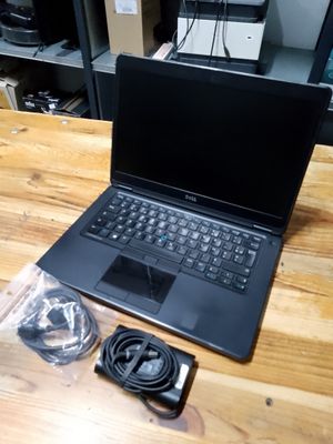 a laptop computer sitting on top of a wooden table