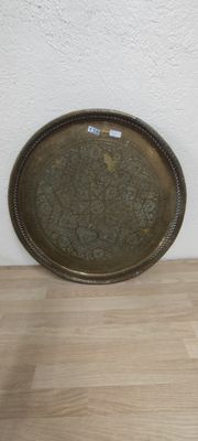 a metal tray sitting on a wooden floor next to a white wall