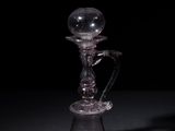 a glass candle holder with a glass ball on top of it