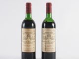 two bottles of wine sitting next to each other on a white surface