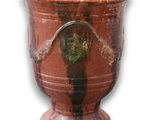 un vase rouge orné d'un cœur sur fond blanc