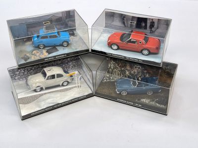 quatre modèles de voitures différents exposés dans une vitrine posée sur un socle blanc