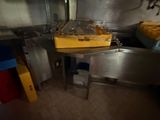 a kitchen with a sink and a counter with a lot of food on it