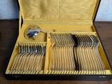 de nombreuses fourchettes et cuillères dans un coffret posé sur une table