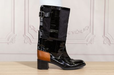 black and brown leather boots with buckles on a wooden floor