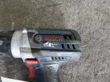 a drill that is sitting on the floor next to a piece of paper