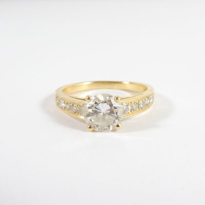 un gros plan d'une bague de fiançailles en or sertie d'un diamant blanc