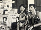 un homme et une femme assis sur un banc devant un journal