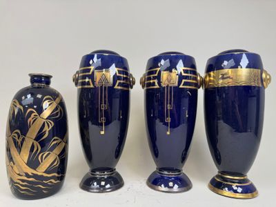 three blue vases with gold designs are lined up on a white surface