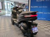 a scooter parked in a showroom with a checkered floor