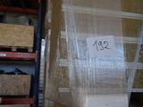 une pile de cartons dans un entrepôt, sur laquelle est apposée une étiquette de prix