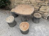 a table and four stools made out of tree stumps