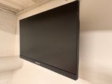 a flat screen tv mounted on the wall in the corner of a room