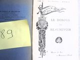 un livre ouvert sur un lit, sur lequel est collé un autocollant jaune
