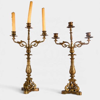 pair of antique brass candelabs with candles on stands