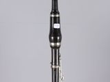 a close up of a black and silver clarinet on a clear surface