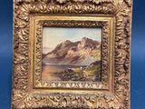 an old picture frame with a painting of a mountain scene on it