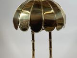 une lampe de table en laiton surmontée d'un abat-jour en laiton