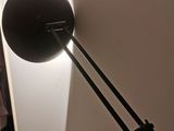 a lamp that is on the wall next to a bed