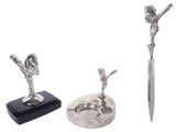 a silver statue of a woman holding a knife next to a pair of scissors