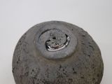 a small gray vase sitting on a white surface