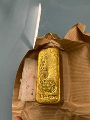 a gold bar in a brown paper bag on a table