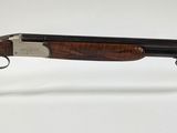 gros plan d'un fusil posé sur un support sur une surface blanche