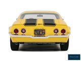 the back end of a yellow car with a license plate on it