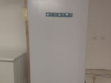 a white refrigerator in the corner of a room