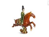 figurine of a man riding a horse on a white background