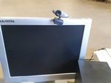 a computer monitor sitting on top of a desk next to a speaker