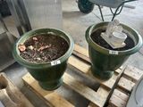 two green pots with dirt in them sitting on a pallet