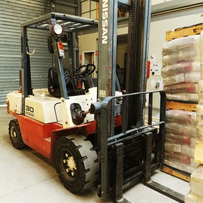 a fork lift truck parked in a warehouse with pallets on the floor