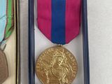two medals in a box on a white surface