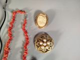 three pieces of jewelry on a table with a necklace, broochet, and a broochet