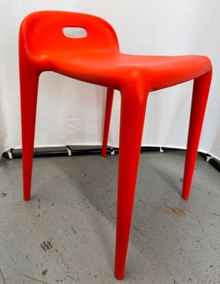 une image représentant une chaise en plastique rouge dans une pièce