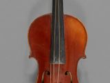 un vieux violon posé sur une table près d'un mur gris
